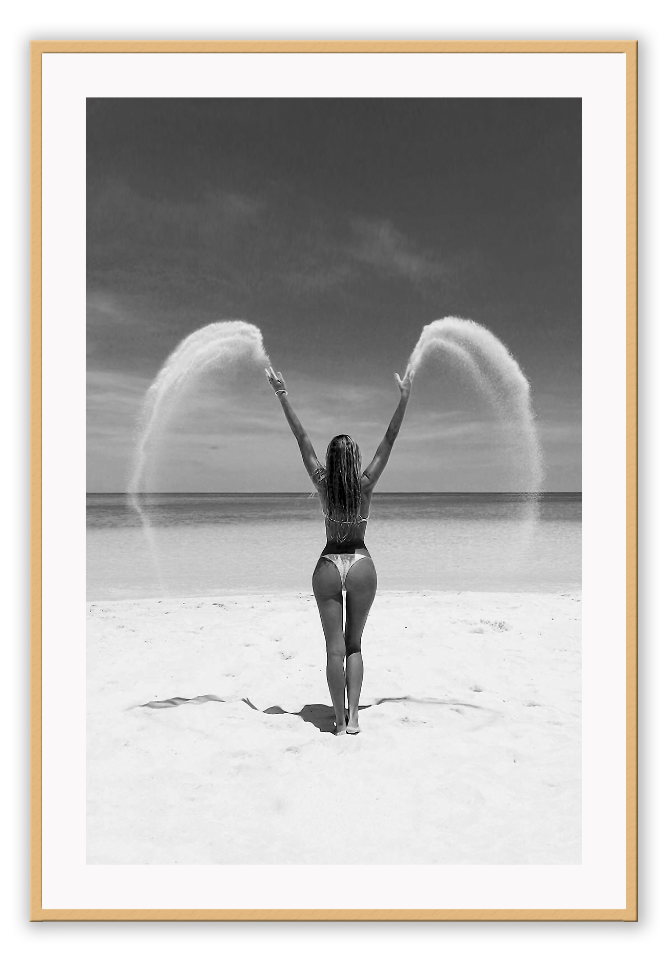 Sexy lady woman throwing sand on a beach in black and white, coastal ocean.