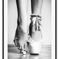 A vintage black and white wall art with a ballerina in point shoes close-up