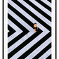 An urban wall art with an aerial view of a lady walking on black and white street crossing stripes