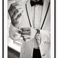 Photography fashion print man adjusting cufflinks on white suit jacket with expensive watch and bow tie 