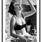 A black and white fashion wall art with a sexy lady in black lingerie eating pasta on the kitchen bench.