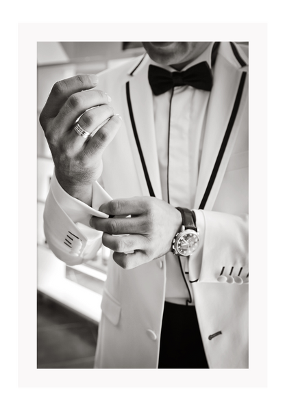Photography fashion print man adjusting cufflinks on white suit jacket with expensive watch and bow tie 