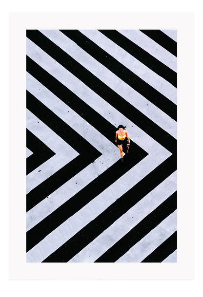 An urban wall art with an aerial view of a lady walking on black and white street crossing stripes