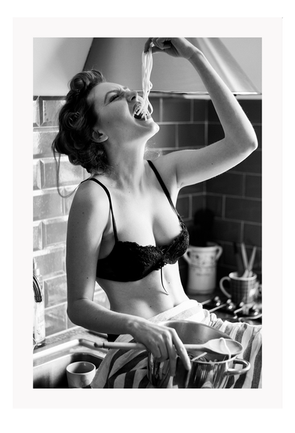 A black and white fashion wall art with a sexy lady in black lingerie eating pasta on the kitchen bench.