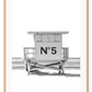 A black and white fashion wall art with black Chanel N5 fashion label on a beach cabin minimal