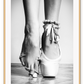 A vintage black and white wall art with a ballerina in point shoes close-up