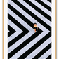 An urban wall art with an aerial view of a lady walking on black and white street crossing stripes