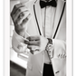 Photography fashion print man adjusting cufflinks on white suit jacket with expensive watch and bow tie 