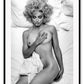 Black and white photography print with Madonna lying on a bed, nude, half covered by sheets and smoking a cigarette.