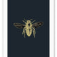 A natural wall art with brass bee on navy blue background that mimics an insect sample