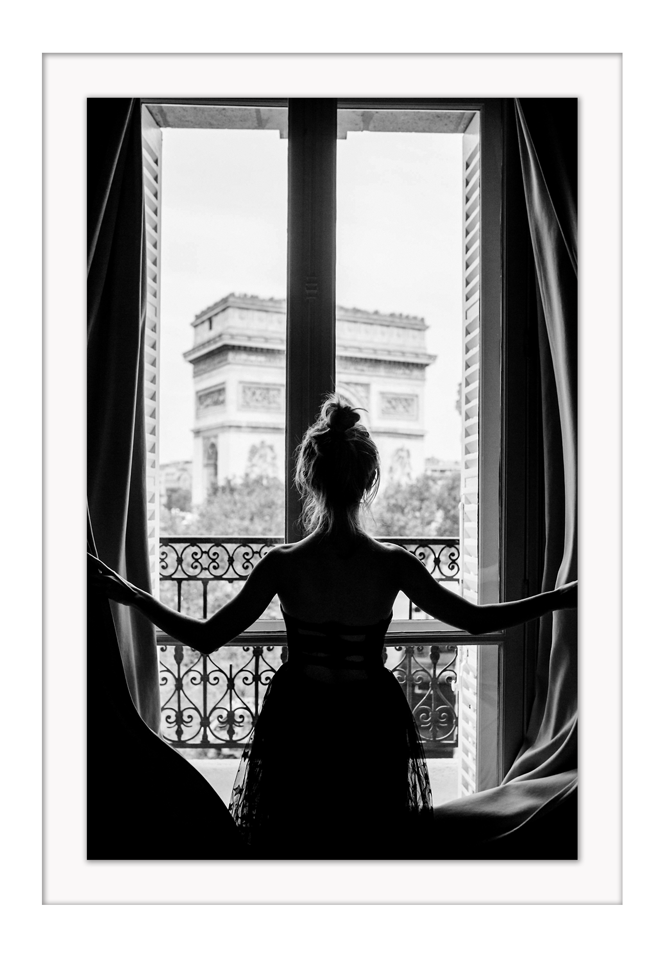 A black and white urban wall art with a girl looking out to the town from a vintage balcony in Paris. 