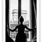 A black and white urban wall art with a girl looking out to the town from a vintage balcony in Paris. 