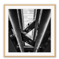 Photography print in black and white with man standing on accending escalator.