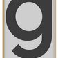 A simple, scandi typography wall art with dark grey writting G on light grey background.