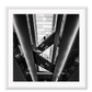 Photography print in black and white with man standing on accending escalator.