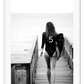 A black and white fashion wall art with fashion model Gisele Bunchen holding Chanel N5 surf board. 
