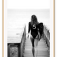 A black and white fashion wall art with fashion model Gisele Bunchen holding Chanel N5 surf board. 