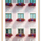 An italian architecture wall art with a pink classic European building facade and floral boutique on balconies. 