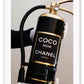 Gold, black and white fire fashion extinguisher with Chanel logo and hand with glove holding